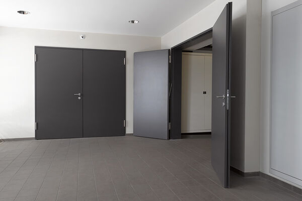 <p><strong>Porte avec huisserie EI30</strong><br />Porte sur huisserie métallique avec ferme-porte asservie à la détection feu.</p>