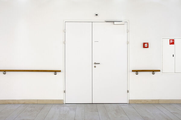 <p><strong>Porte avec huisserie EI30</strong><br />Porte sur huisserie métallique, vantail affleuré, avecferme-porte en applique.</p>